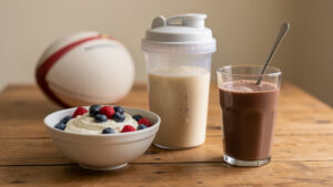 Collation protéinée du soir après le rugby avec un bol de skyr, un shaker de boisson protéinée et un verre de lait chocolaté.